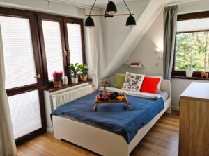 pokój z łóżkiem i balkonem