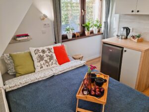 śniadanie na łóżku, obok szafki i lodówka