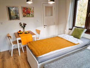 pokój z dwoma łóżkami pojedynczymi i stolikiem