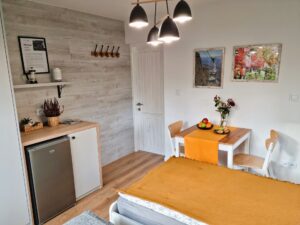 pokój z dwoma łóżkami pojedynczymi, szafą i lodówką