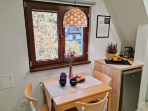 pokój ze stolikiem i małą lodówką