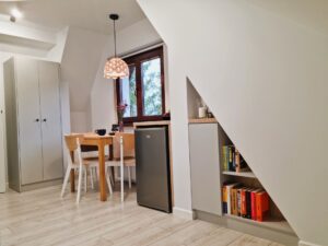 pokój z szafą, stolikiem i lodówką