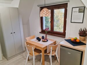 pokój ze stolikiem, szafką i lodówką