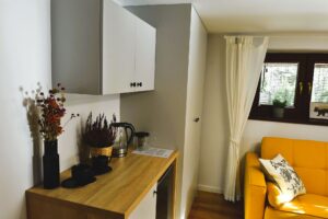 pokój z szarymi szafkami i żółtą kanapą