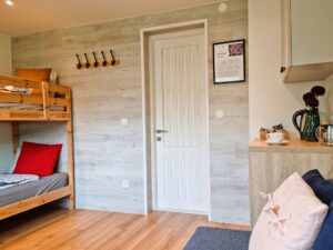 pokój z małym aneksem kuchennym i łóżkiem dwupoziomowym